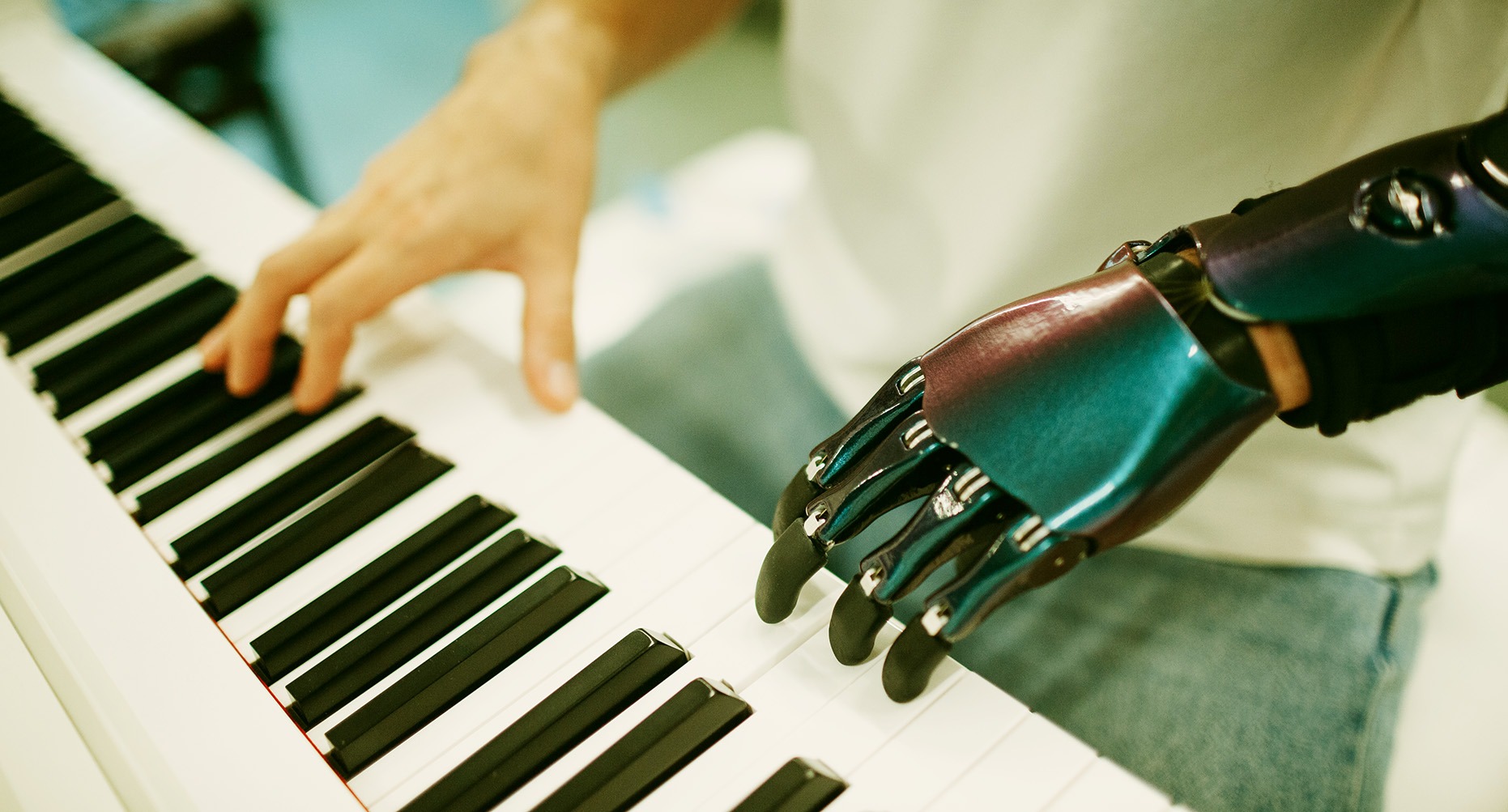 Eine menschliche Hand und eine bionische Roboterhand spielen gemeinsam Klavier – Symbol für KI und Kreativität im Musikunterricht.