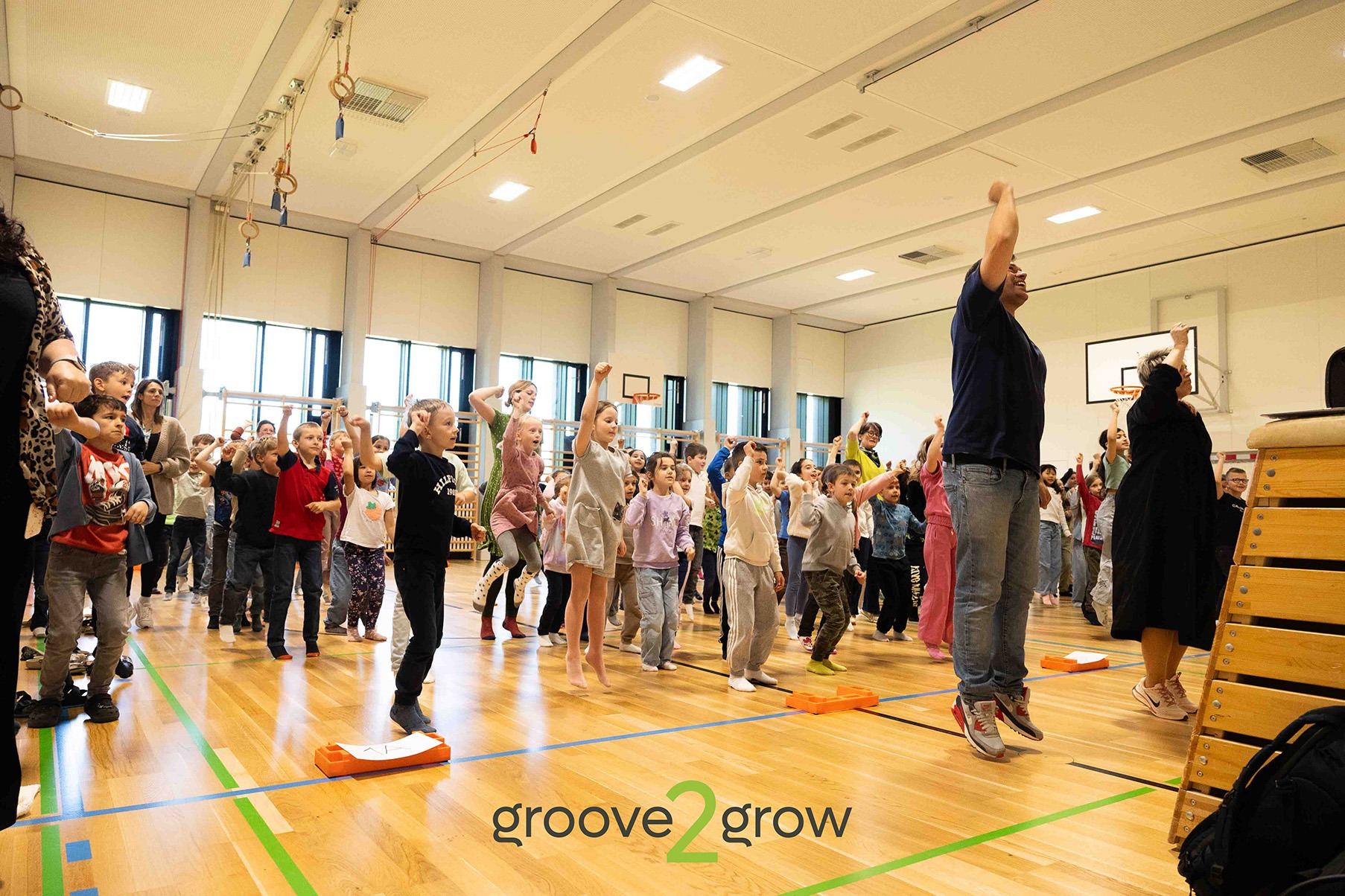 PH NÖ & groove2grow: Gemeinsam für Bewegung Große Gruppe von Kindern und Lehrkräften tanzt gemeinsam in der Turnhalle – Kooperation zwischen PH NÖ und groove2grow.