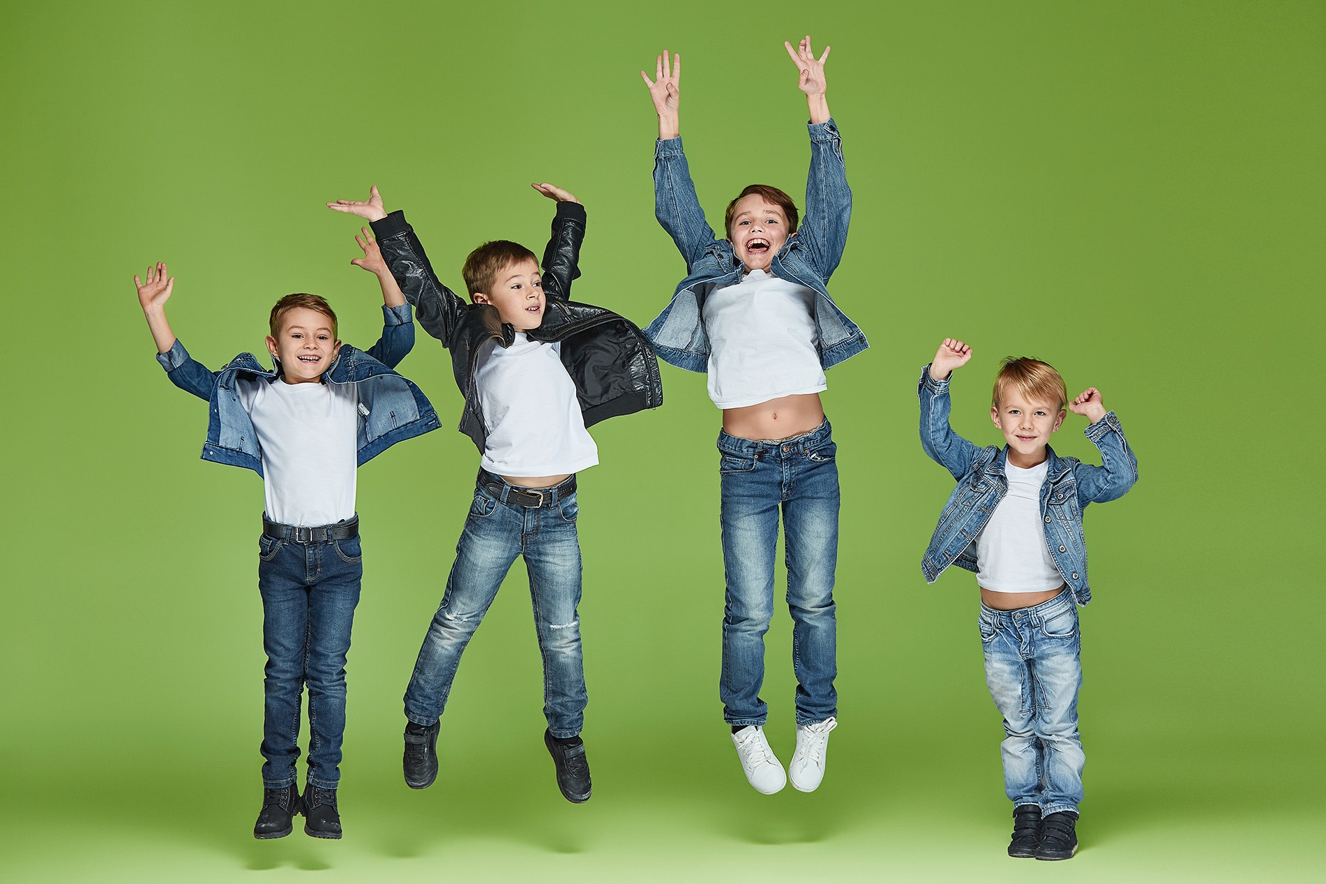 Musikunterricht modern gestalten – Sekundarstufe I Vier Jungen springen vor Freude vor einem grünen Hintergrund – Tipps für modernen Musikunterricht in der Sekundarstufe I mit groove2grow.