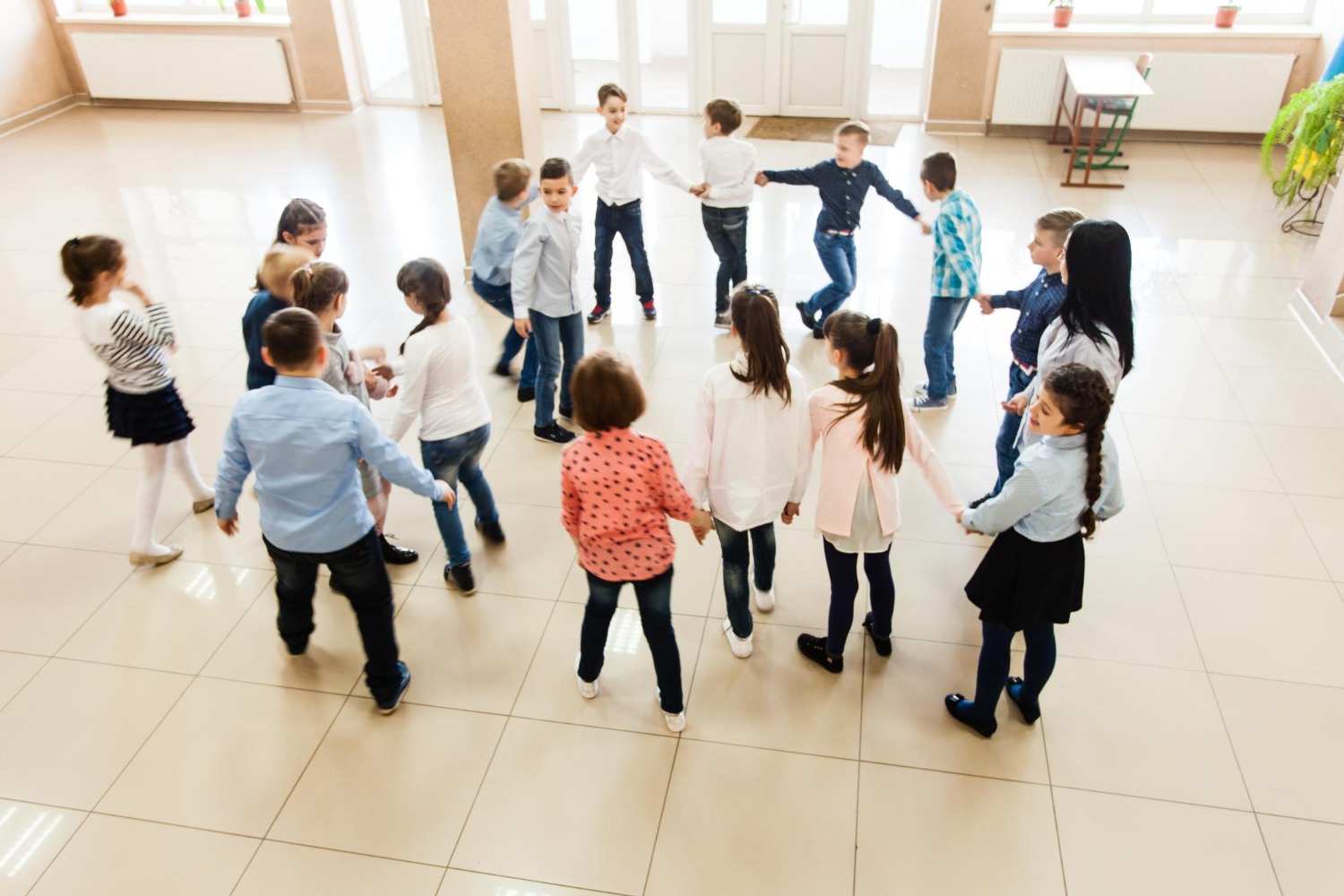 Warum Tanz in der Schule oft scheitert Eine Gruppe von Kindern tanzt im Kreis in einer Schulaula – Herausforderungen und Lösungen für Tanz im Schulalltag.