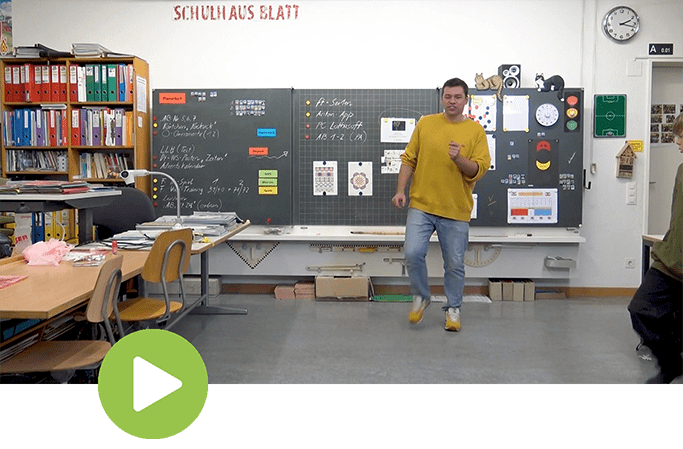 Der Lehrer zeigt den Tanzschritt Reebok im Klassenzimmer – groove2grow MOVES Tutorial.