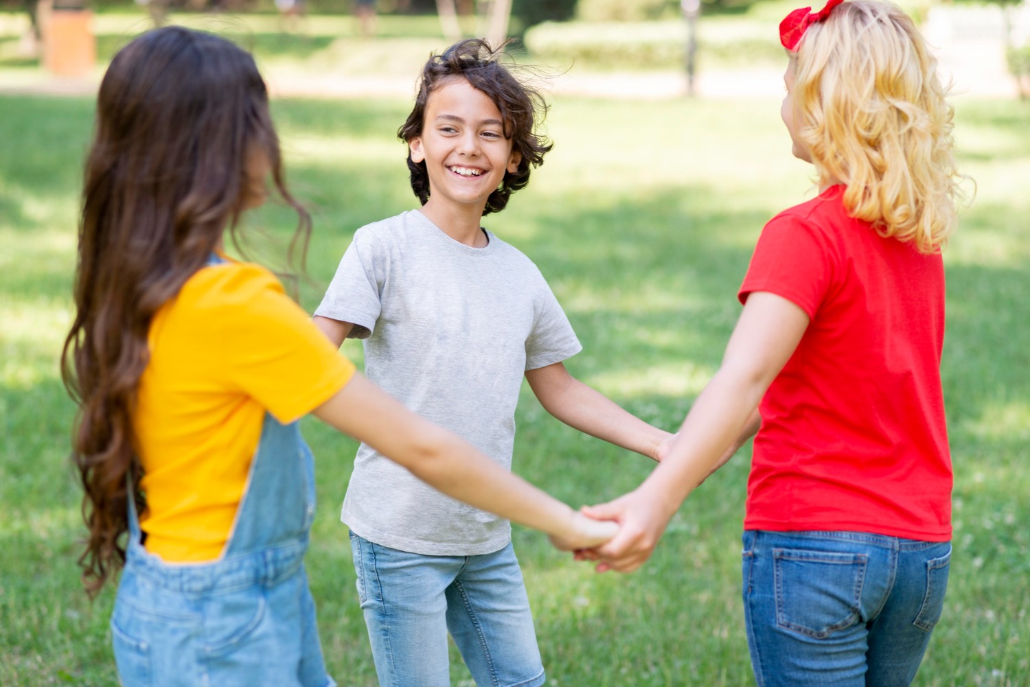 The Science of Groove: Warum Rhythmus verbindet Drei Kinder halten sich im Kreis an den Händen und lachen – Illustration für soziale Verbundenheit und das Wir-Gefühl durch gemeinsamen Rhythmus.