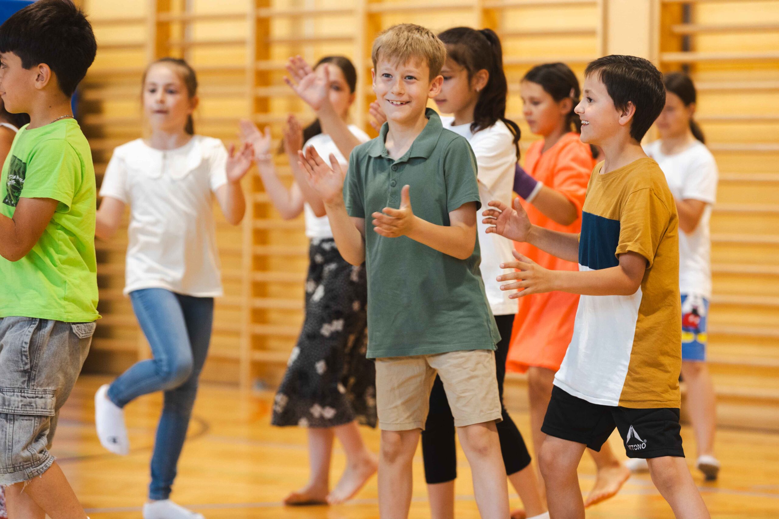 Freude und Gemeinschaft beim Tanzprojekt Wels Lachende Schüler beim gemeinsamen Tanzen und Klatschen im Rahmen des groove2grow Projekts in Wels.