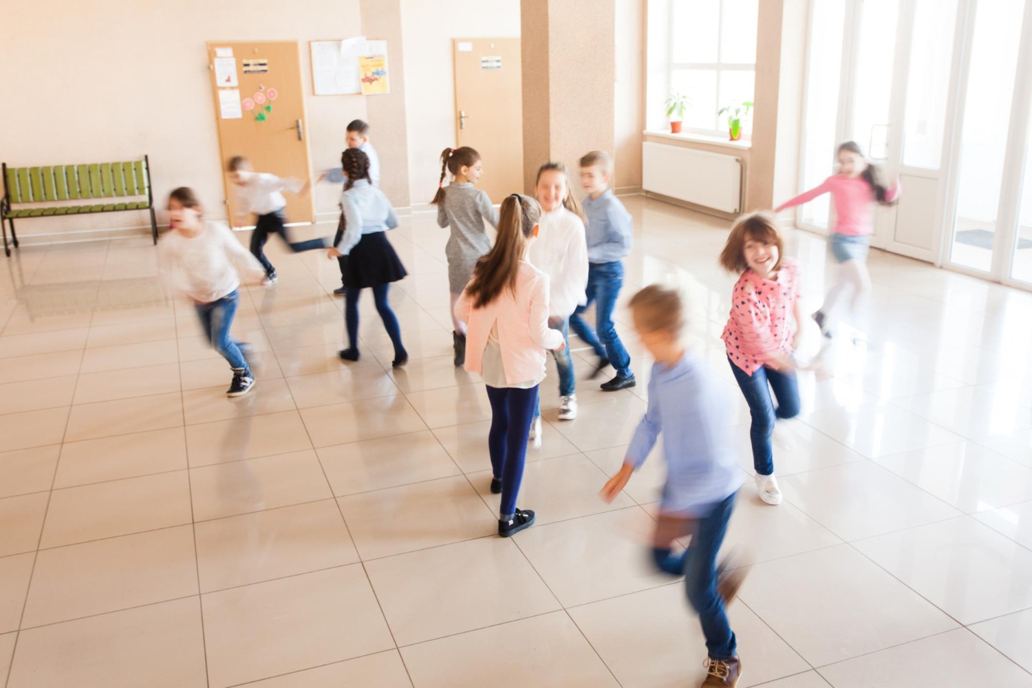 Bewegungsdrang vs. Schulalltag: Die Herausforderung für Lehrkräfte Verschwommene Aufnahme von spielenden und rennenden Kindern in einem hellen Schulflur – Ausdruck von Energie und Bewegungsdrang.