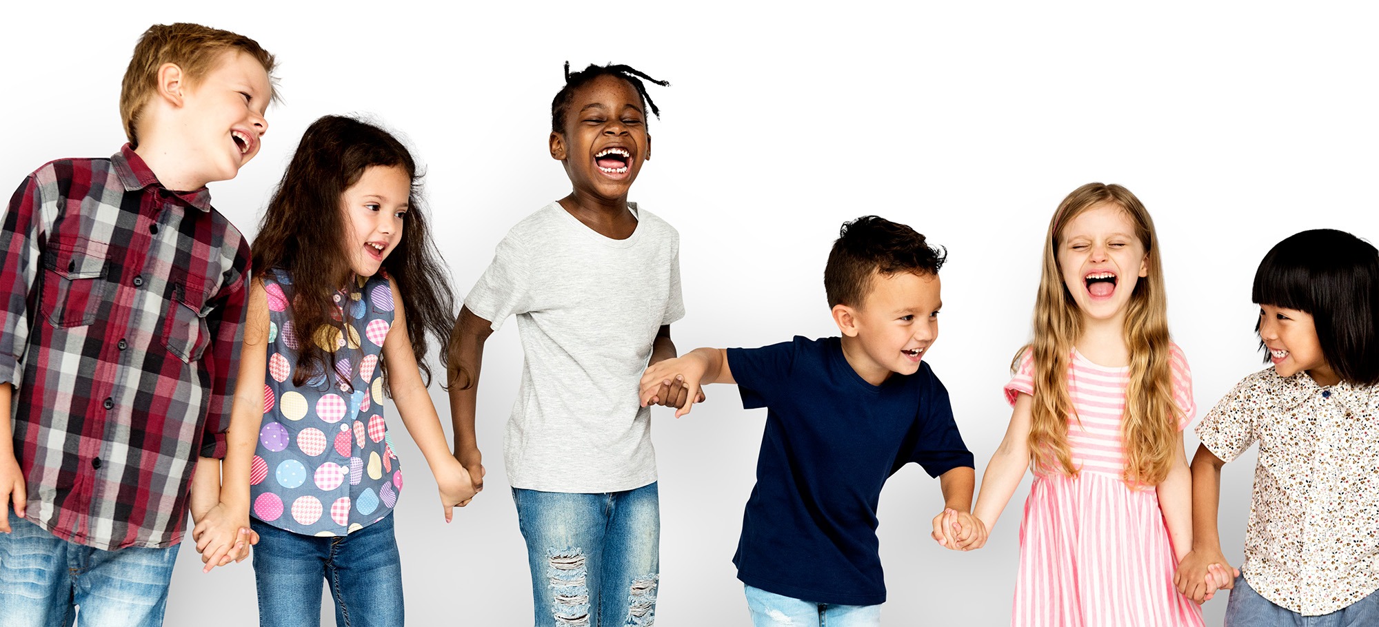Biologischer Klebstoff: Vertrauen und Freude durch Gruppentanz Eine diverse Gruppe von sechs glücklichen Kindern hält sich an den Händen, lacht und bewegt sich gemeinsam vor einem weißen Hintergrund – Symbol für soziale Bindung durch Bewegung.