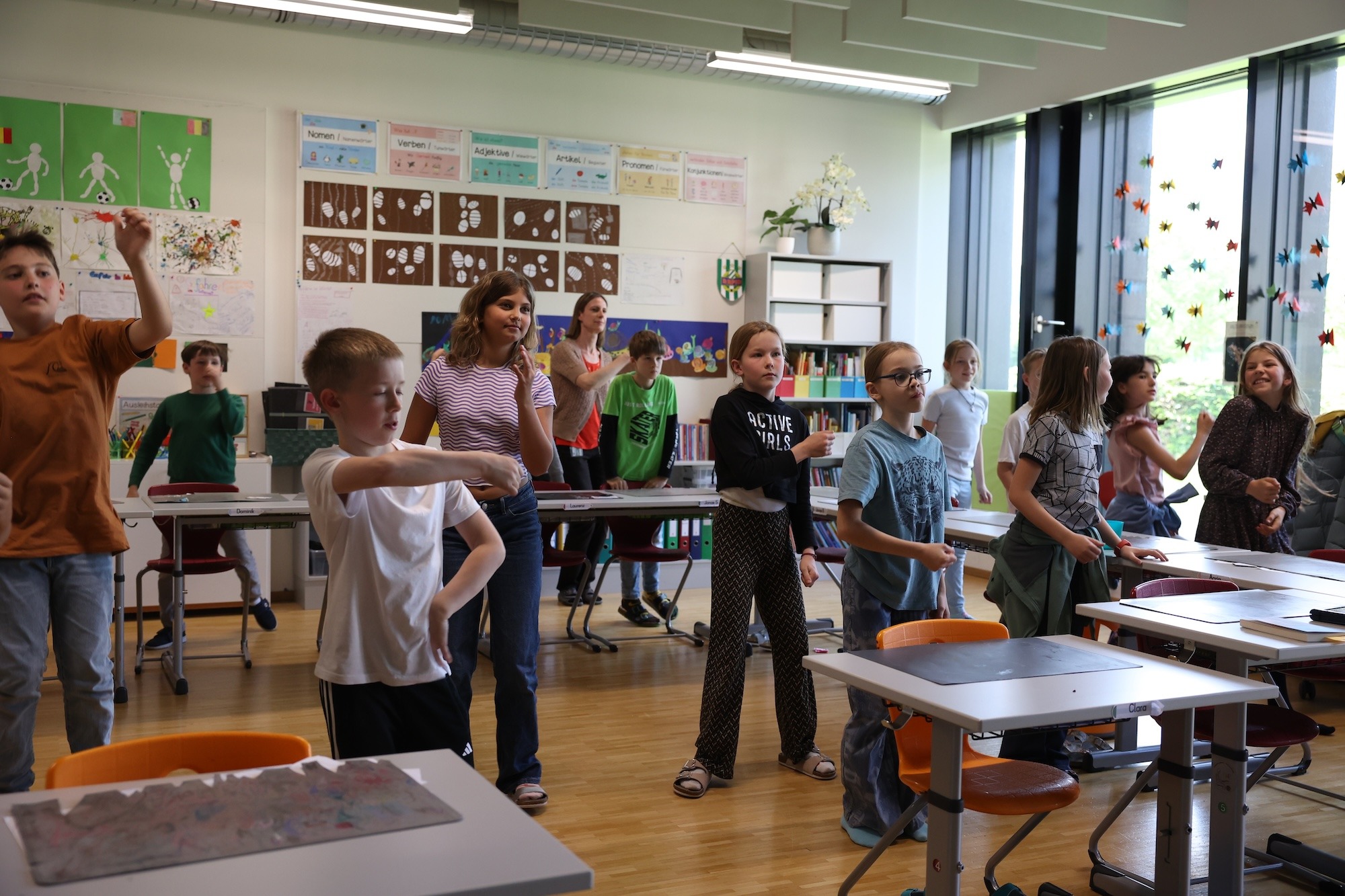 Kleine Momente, große Wirkung: Selbstvertrauen durch Tanz Eine Schülerin führt konzentriert eine Tanzbewegung in der Klasse aus, während andere Kinder im Hintergrund beobachten – ein Moment individueller Ausdruckskraft.