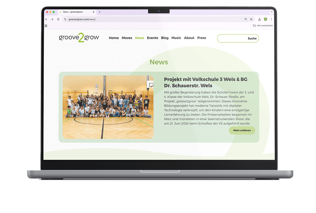 Ein Laptop-Bildschirm zeigt einen News-Beitrag über ein erfolgreiches Tanzprojekt an der Volksschule 3 Wels mit groove2grow.